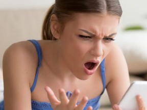 Shocked young woman using digital tablet at home