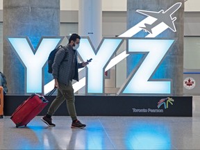 A traveller passes a YYZ airport code sign in the international arrival lounge amid a growing global number of coronavirus cases at Pearson Airport in Toronto, March 13, 2020.