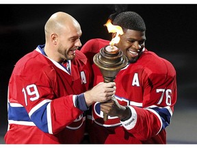 Andrei Markov takes torch from P.K. Subban during ceremony before the Canadiens’ home opener at the Bell Centre on Oct. 16, 2014.