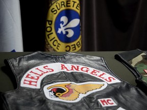 Surete du Quebec display Hells Angels vests as they speak to the media after a series of raids.