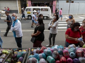 Customers wearing masks wait to buy in downtown Sao Paulo during the fist day of commerce opening since the beginning of quarantine due to the coronavirus (COVID-19) pandemic on June 10, 2020 in Sao Paulo, Brazil.