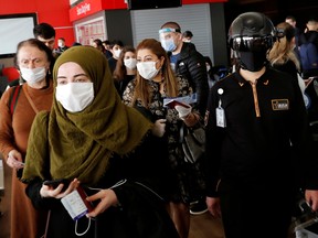 A security employee monitors passengers as they wait to board a  flight to Germany at Sabiha Gokcen Airport in Istanbul, Turkey during the coronavirus outbreak, June 11, 2020.