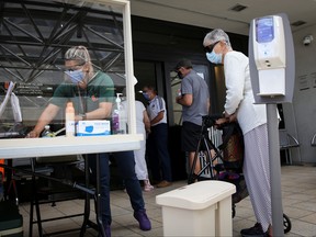 A woman waits for health assessment check-in before entering Jackson Memorial Hospital, as Miami-Dade County eases some of the lockdown measures put in place during the coronavirus outbreak, in Miami, Florida, June 18, 2020.