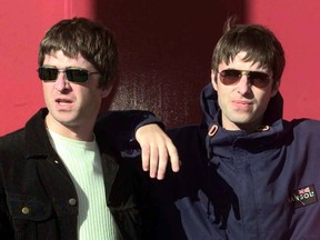 Liam Gallagher (R) and his songwriting brother Noel walk out of the concert hall for a photo-opportunity prior to the first date on their 1997 UK tour, September 13.