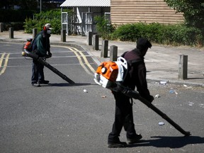 Workers clean rubbish from the street at Angell Town estate in Brixton, London, Britain, June 25, 2020.