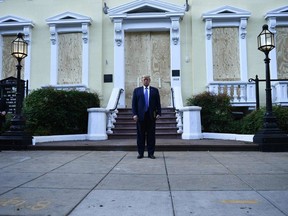 U.S. President Donald Trump holds a bible in front of boarded up St John's Episcopal church after walking across Lafayette Park from the White House in Washington, DC on June 1, 2020.