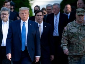 In this file photo US President Donald Trump walks with US Attorney General William Barr (L), US Secretary of Defense Mark T. Esper (C), Chairman of the Joint Chiefs of Staff Mark A. Milley (R), and others from the White House to visit St. John's Church after the area was cleared of people protesting the death of George Floyd June 1, 2020, in Washington, DC.