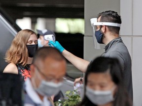Visitors have their temperatures checked as they arrive at Universal Studios theme park on the first day of reopening after the shutdown during the coronavirus pandemic, on June 5, 2020, in Orlando, Florida.