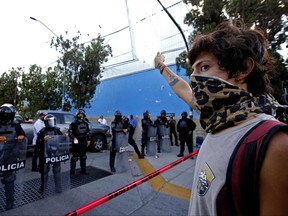 A young man demonstrates in front of a line of riot police following the death of a young man while in police custody, after he had been arrested allegedly for failing to comply with measures to prevent the spread of COVID-19 coronavirus, on June 5, 2020, in Guadalajara, Jalisco state, Mexico.