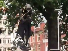 This still image taken from a June 7, 2020, video courtesy of William Want (@willwantwrites) via Twitter, shows protesters pulling down a statue of slave trader Edward Colston in Bristol, south west England, during a demonstration organised to show solidarity with the Black Lives Matter movement in the wake of the killing of George Floyd, an unarmed black man who died after a police officer knelt on his neck in Minneapolis.