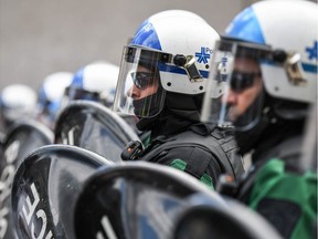 Montreal Police form a line in front of protesters during a march against police brutality and racism in Montreal on June 7 2020.