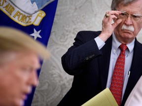 In this file photo taken on May 13, 2019, National Security Advisor John Bolton listens while U.S. President Donald Trump speaks to the press before a meeting with Hungary's Prime Minister Viktor Orban in the Oval Office of the White House in Washington, D.C.