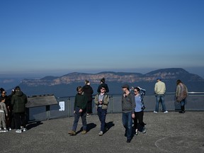 Tourists take in the view at a Three Sisters rock formation lookout in Blue Mountains National Park in the wake of regional travel re-opening as the coronavirus disease (COVID-19) restrictions are eased in New South Wales, in Katoomba, Australia.

China on Tuesday urged students going overseas to think carefully before choosing Australia, citing a spate of racist incidents targeting Asians during the COVID-19 pandemic and putting A$12 billion ($8.3 billion) of fee revenue at risk.