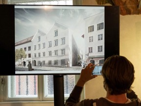 A journalist takes pictures of a screen showing the chosen plan for the architectural redesign of Adolf Hitler's birth house, during a press conference at the Interior ministry in Vienna, Austria on Tuesday, June 2, 2020.