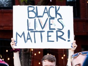 A protester holds a sign during a march in support of Black Lives Matter and Black Trans Lives in Boystown on June 14, 2020 in Chicago.