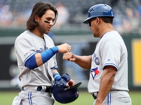 Blue Jays baserunner Bo Bichette, left, is fist-bumped by Luis Rivera after being stranded on base during MLB action against the Royals at Kauffman Stadium in Kansas City, Mo., July 31, 2019.