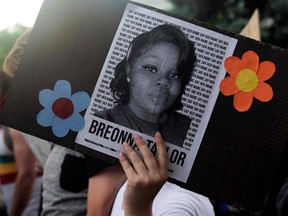 A demonstrator holds a sign with the image of Breonna Taylor, a black woman who was fatally shot by Louisville police officers, during a protest against the death of George Floyd in Minneapolis, in Denver, on June 3, 2020.