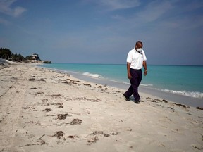 A security guard wearing a protective mask walks on the beach amid concerns about the spread of COVID-19, in Varadero, Cuba, April 10, 2020.