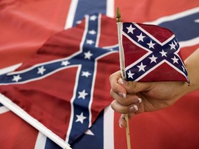 An employee holds up a Confederate flag during the manufacturing process at the Alabama Flag and Banner on April 12, 2016 in Huntsville, Alabama.