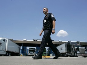 A U.S. Customs and Border Protection officer walks past a truck inspection station at the U.S. border in Buffalo, N.Y., Tuesday, June 6, 2006.