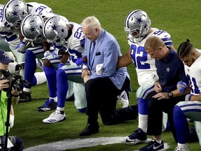 In this Sept. 25, 2017, file photo, the Dallas Cowboys, led by owner Jerry Jones, take a knee prior to the national anthem before a game against the Arizona Cardinals in Glendale, Ariz.
