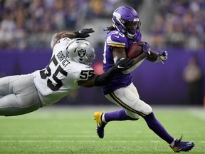 Dalvin Cook of the Minnesota Vikings avoids a tackle by Vontaze Burfict of the Oakland Raiders at U.S. Bank Stadium on September 22, 2019 in Minneapolis.