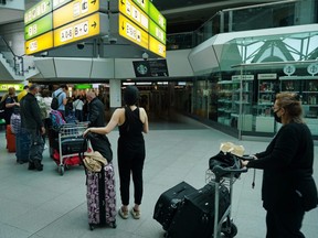 Travelers wait in line to board a flight to Turkey at Tegel Airport during the coronavirus pandemic in Berlin, Germany, June 19, 2020.