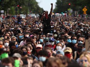 A man holds up his fist while hundreds of demonstrators march to protest against police brutality and the death of George Floyd, on June 2, 2020, in Washington, D.C.