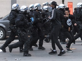 Police push back protesters during a demonstration calling for justice in the death of George Floyd and victims of police brutality in Montreal, Sunday, May 31, 2020.