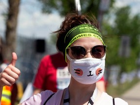A woman wearing a face mask gives a thumbs-up as healthcare workers, professionals and unions demanding safer working conditions and time off amid the coronavirus disease (COVID-19) outbreak protest in front of Santa Cabrini Hospital in Montreal, Quebec, Canada May 29, 2020.