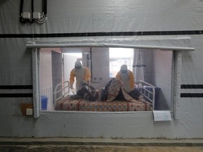 Moise Vaghemi, 33, (L) an Ebola survivor who works as a nurse cares for a patient who is suspected to be suffering from Ebola, inside the Biosecure Emergency Care Unit (CUBE) at the Ebola treatment centre in Katwa, near Butembo, in the Democratic Republic of Congo, October 3, 2019.