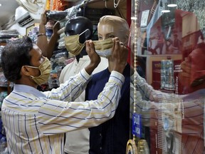 A worker adjusts a protective face mask on a mannequin at a garment shop after shops reopened as India eases lockdown restrictions that were imposed to slow the spread of the coronavirus disease (COVID-19), in Kolkata, India, June 10, 2020.