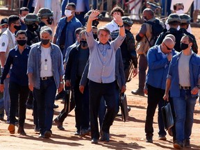 Brazil President Jair Bolsonaro (centre) waves to supporters during the inauguration of a field hospital in Aguas Lindas, in Goiais state, on Friday, June 5, 2020, amid the COVID-19 pandemic.