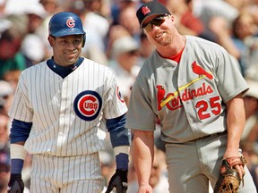 The Chicago Cubs' Sammy Sosa stands with St. Louis Cardinal's first baseman Mark McGwire between pitches after Sosa singled in the second inning on May 28, 1999, at Wrigley Field in Chicago.