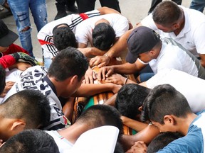 Friends of Alexander Martinez, a 16-year-old boy who was shot dead by municipal police officers, react over his coffin during his funeral, in Oaxaca state, Mexico June 11, 2020.