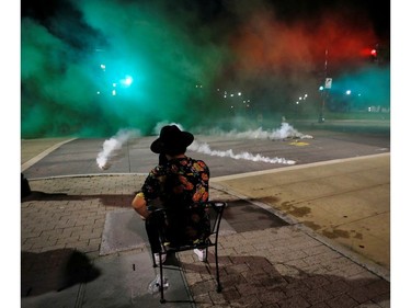 A protester sits while riot police fire tear gas in his direction during nationwide unrest following the death in Minneapolis police custody of George Floyd, in Raleigh, North Carolina, U.S. May 31, 2020. Picture taken May 31, 2020. REUTERS/Jonathan Drake ORG XMIT: JAD113