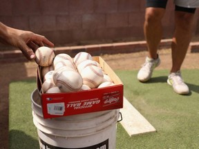 Baseballs are taken from a box as MLB pitchers practice in a backyard throwing session on in Scottsdale, Ariz., June 5, 2020.