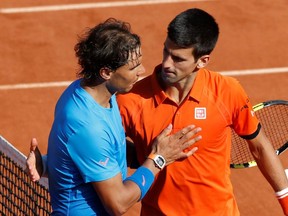 Novak Djokovic (right) hugs Rafa Nadal following his 7-5 6-3 6-1 victory in the French Open quarterfinals at Roland Garros in Paris.