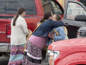 Members of the local First Nations hug outside the arrivals area of the Fredericton Airport in Lincoln, New Brunswick on Monday June 8, 2020. The members were there to greet family members of a 26-year-old Indigenous woman Chantel Moore who was fatally shot by police in Edmundston, N.B.