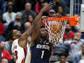 Pelicans forward Zion Williamson (right) dunks against Heat forward Bam Adebayo (left) during NBA actino at the Smoothie King Center in New Orleans, March 6, 2020.