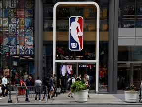 The NBA logo is displayed as people pass by the NBA Store in New York on October 7, 2019.