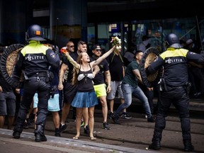 A woman reacts towards police at The Hague's Central Station as people gather at the Malieveld grounds to demonstrate against the Dutch government's handling of the COVID-19 pandemic, on Sunday, June 21, 2020.