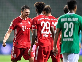 Bayern Munich defender Benjamin Pavard (left) celebrates with his teammates during their game against SV Werder Bremen on June 16, 2020 in Bremen.