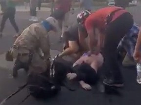 Attendees help a man who was shot and wounded during clashes between protesters trying to pull down a statue of Juan de Onate and armed members of civilian militia group New Mexico Civil Guard in downtown Albuquerque, New Mexico,June 15, 2020, in this still image obtained from a social media video.