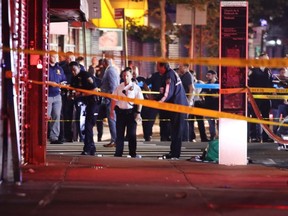 Police gather at the scene where two New York City police officers were shot in a confrontation in Brooklyn late Wednesday, June 3, 2020.