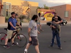 Alleged gunman that shot at protesters is pictured surrounded by armed men in Albuquerque, New Mexico June 16, 2020 in this screen grab obtained from a social media video.