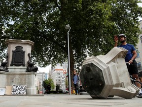A man observes the base of the statue of Edward Colston, after protesters pulled it down and pushed into the docks, following the death of George Floyd who died in police custody in Minneapolis, Bristol, Britain, June 8, 2020.