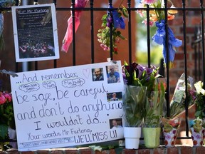 Floral tributes are left on the railings outside The Holt School in Wokingham, England, June 23, 2020, in memory of teacher James Furlong who was a victim in the knife attack in Reading which left three people dead.