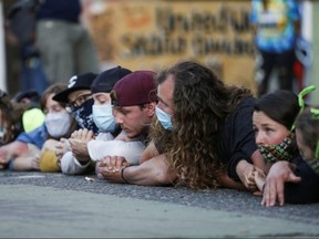 People lie down on the street after some believed police would arrive outside the Seattle Police Department's East Precinct in Seattle, Washington June 22, 2020.