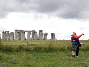 A couple take a selfie as they pass near by the Stonehenge stone circle near Amesbury, Britain June 20, 2020.